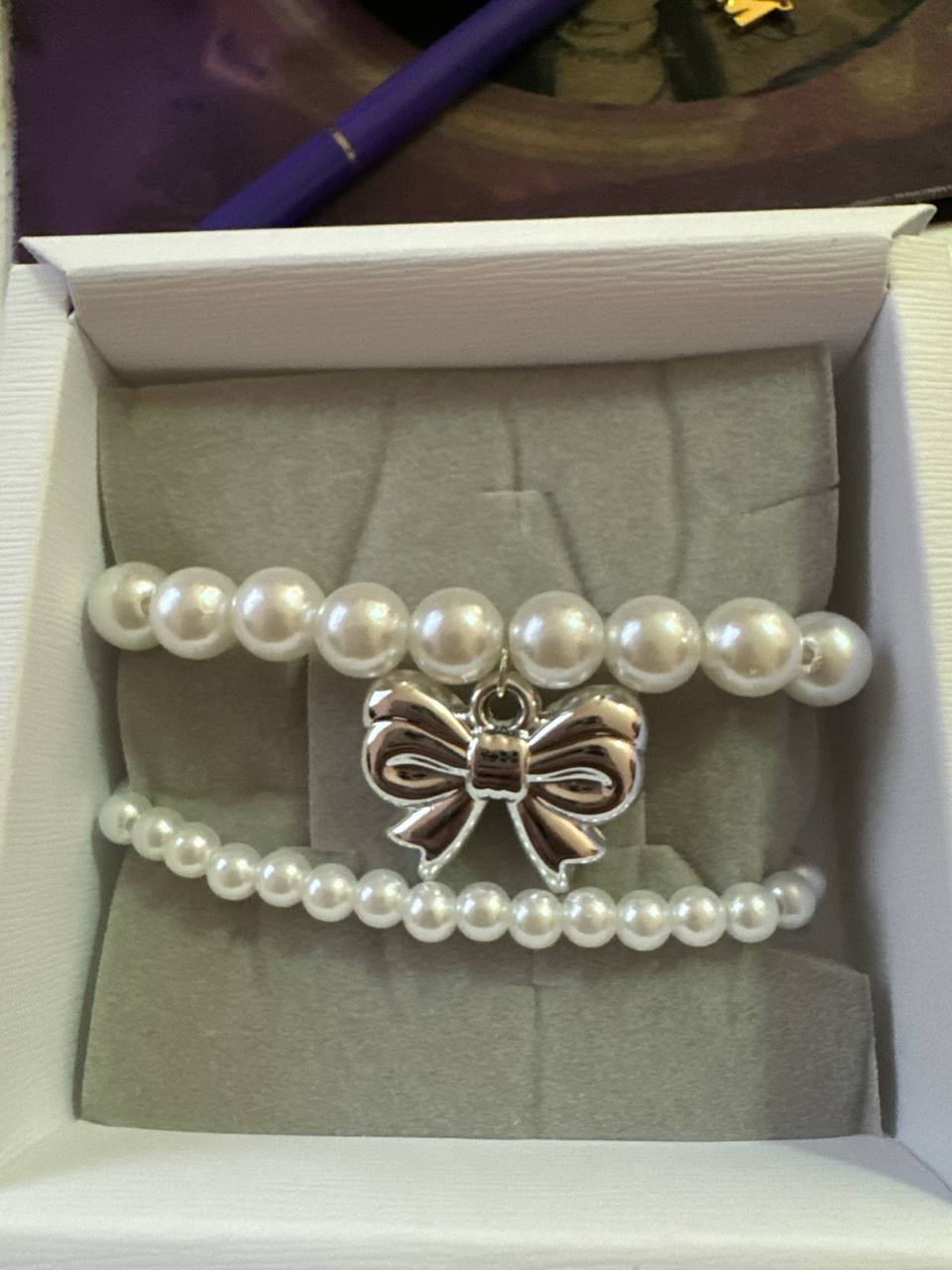 DOPPIO BRACCIALE CON PERLE CON ELASTICO CON CHARM FIOCCO