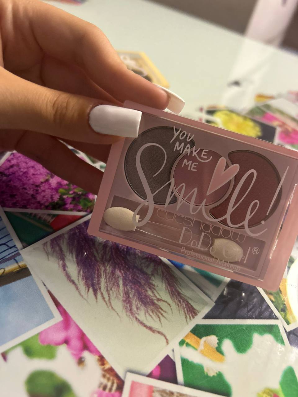 palette di ombretti del marchio "DoDo Girl", che include diverse tonalità e un pennello per l'applicazione